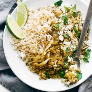 White rice and lentils with shredded chicken, fresh cilantro and quartered lime slices.