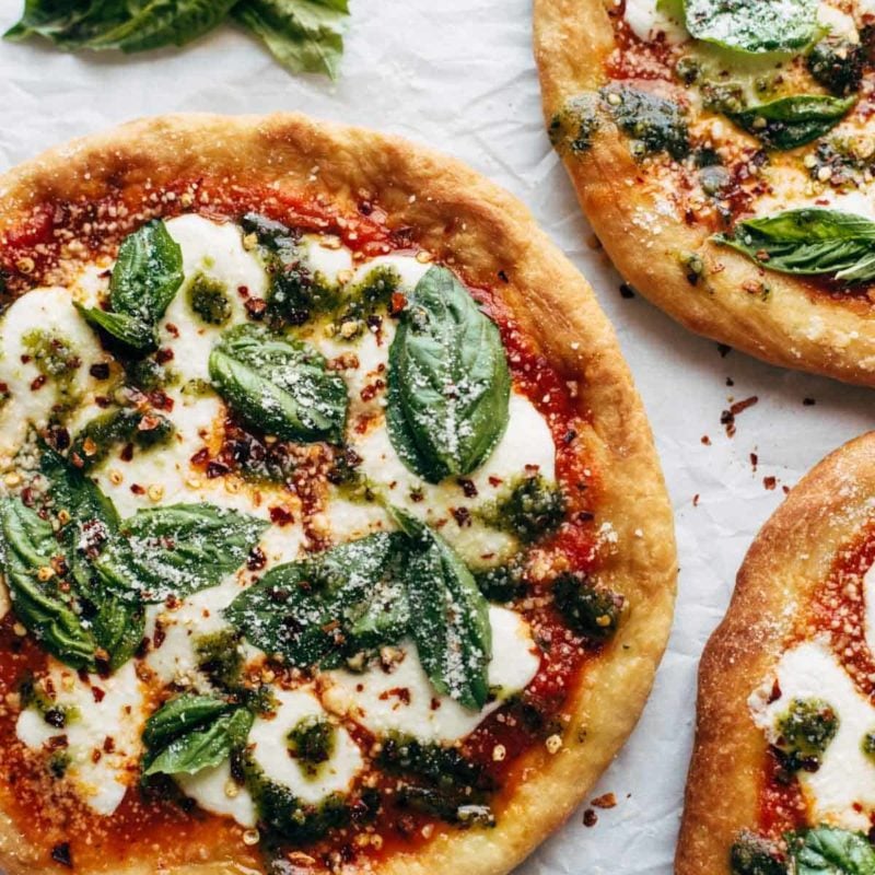 Fried Pizzas on parchment paper with basil.