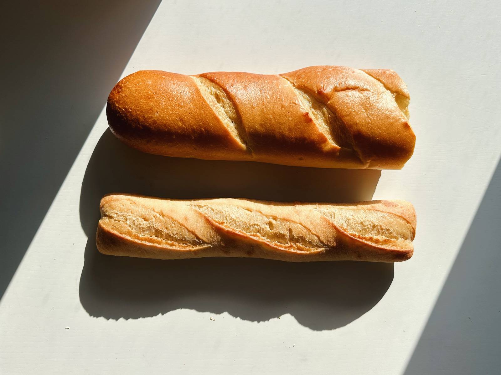 Two loaves of bread - a baguette and French bread.