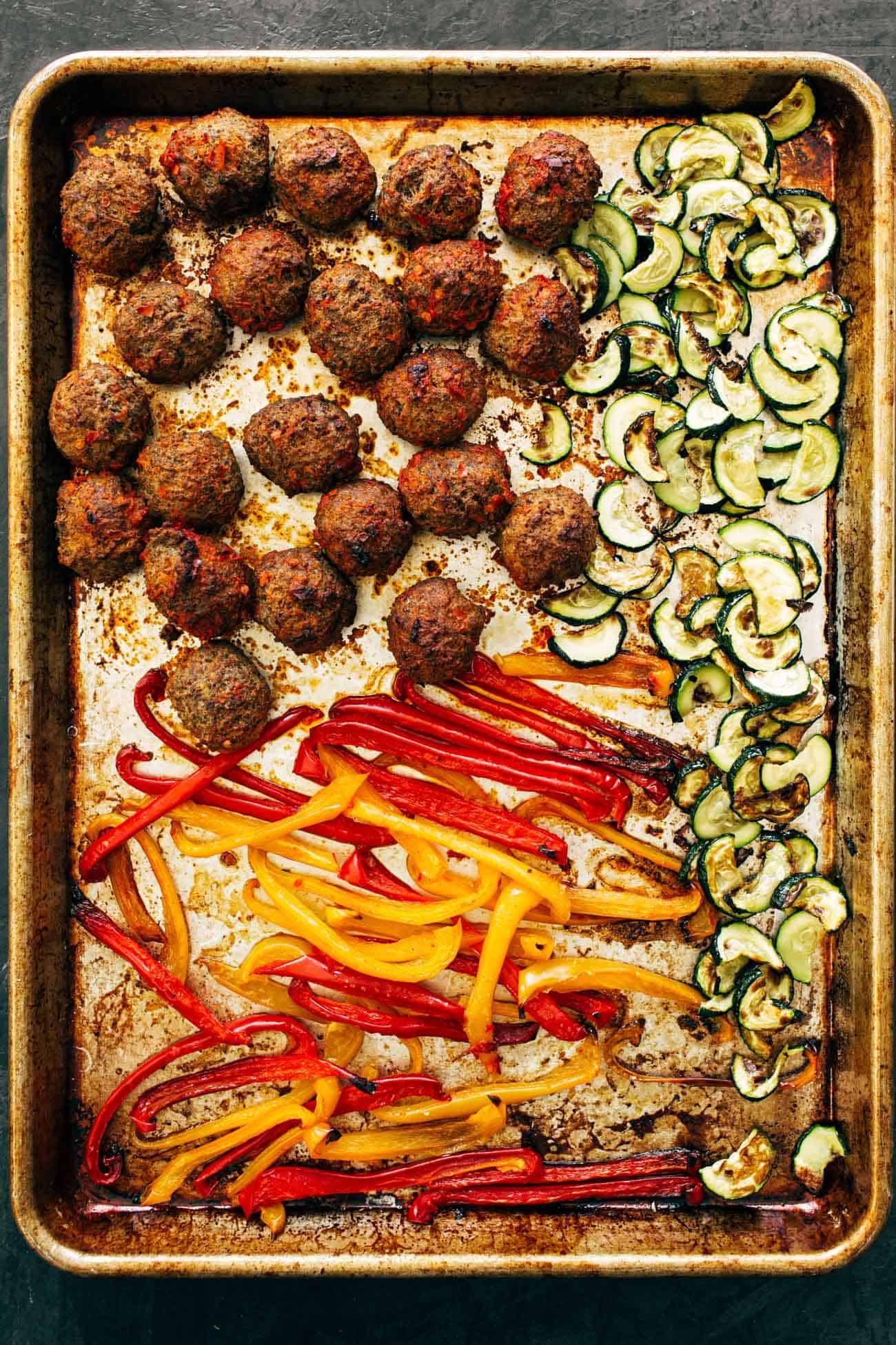 Cooked ingredients on a sheet pan for Harissa Meatballs with Whipped Feta