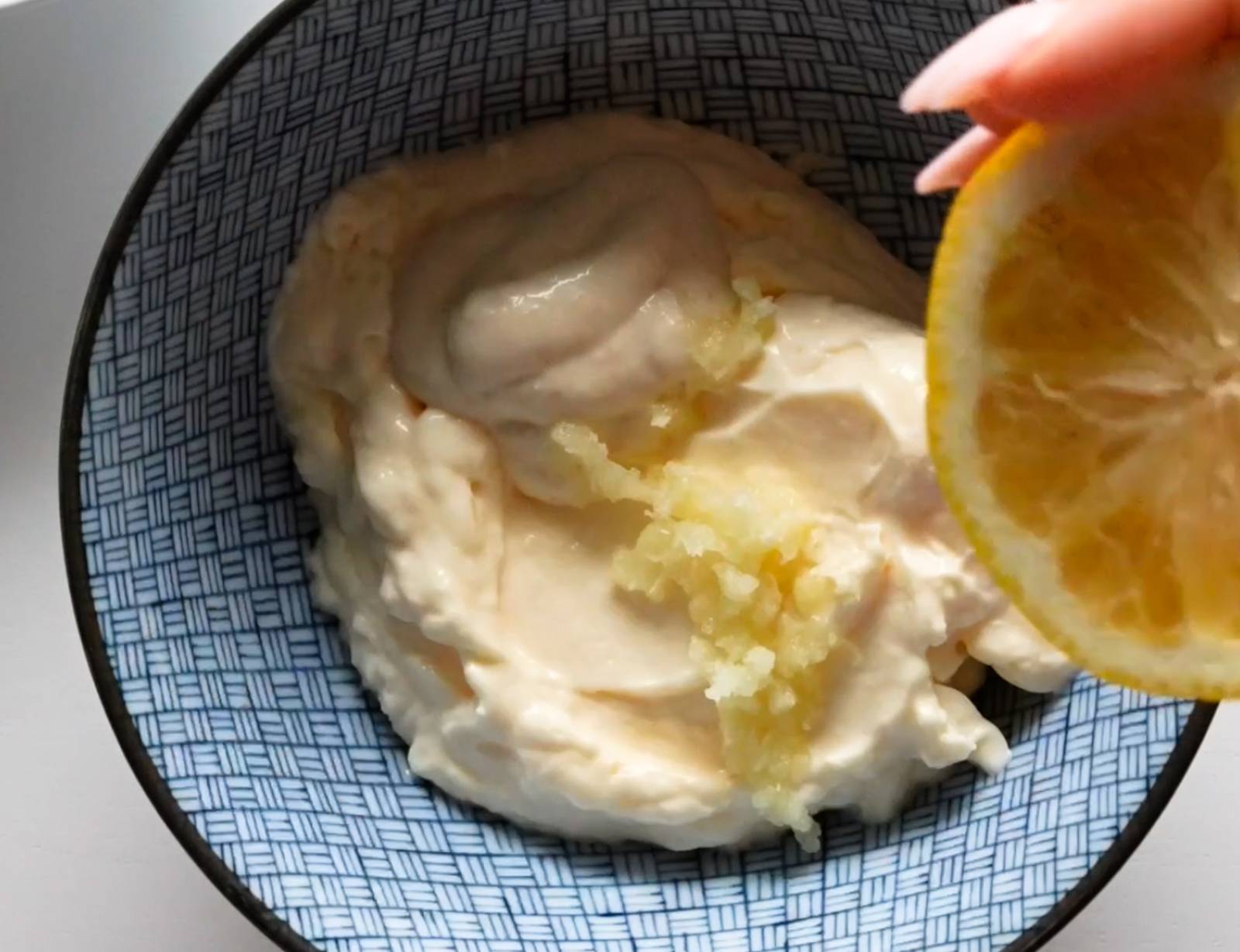 Mixing aioli in a bowl with mayonnaise, horseradish, garlic, and lemon juice.