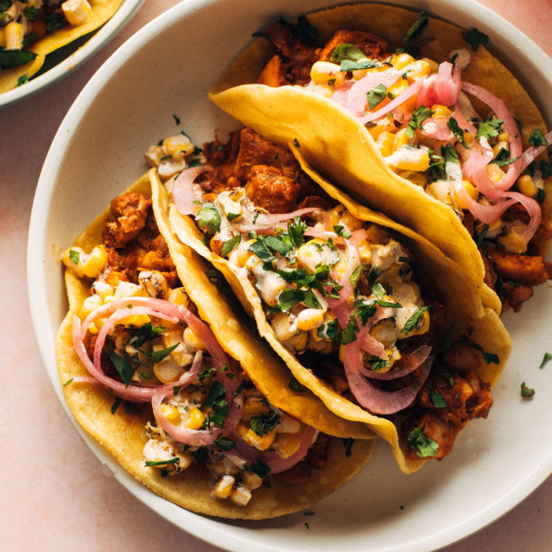 Chicken tacos on a plate with creamy corn