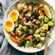 Roasted Vegetable Bowls with Green Tahini and a side of egg and a spoon in the bowl.