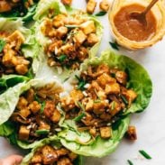 Firecracker Vegan Lettuce wraps in a row with hand.